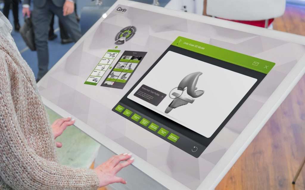 person interacting with Corin interactive touchscreen software displayed on large white tablet