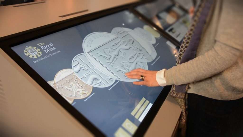 Woman interacting with The Royal Mint interactive touchscreen presentation